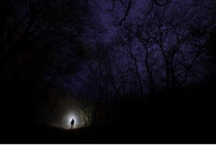 vue lointaine d'une personne avec une petit lumière dans l'obscurité
